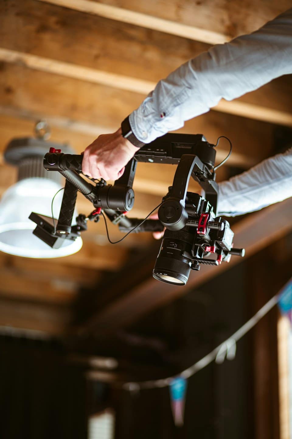 Mani che utilizzano una fotocamera professionale montata su uno stabilizzatore gimbal.