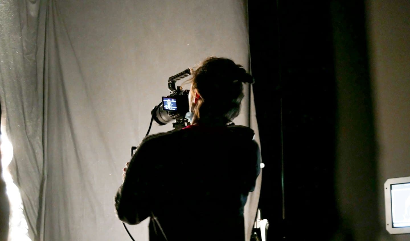 Un videografo in uno studio che opera una telecamera professionale.