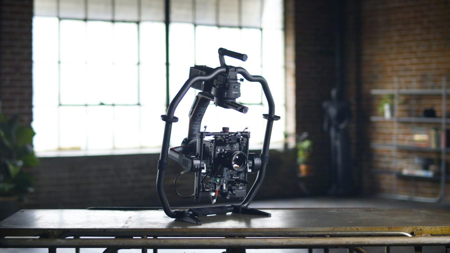 Una cinepresa digitale montata su uno stabilizzatore gimbal su un tavolo di metallo.