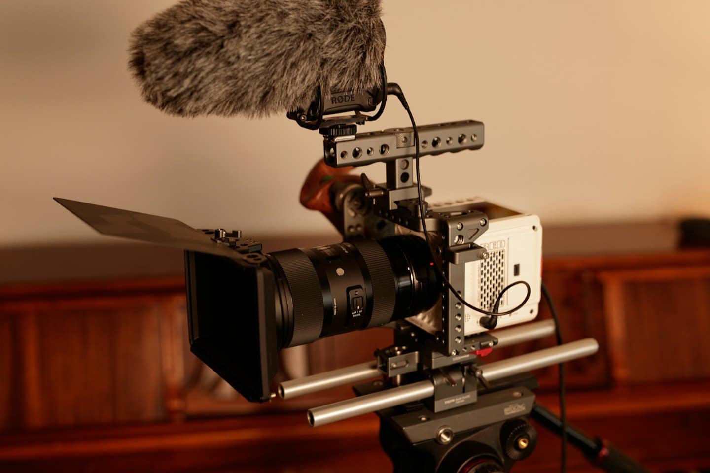 Videocamera professionale con microfono a fucile montata su un treppiede.