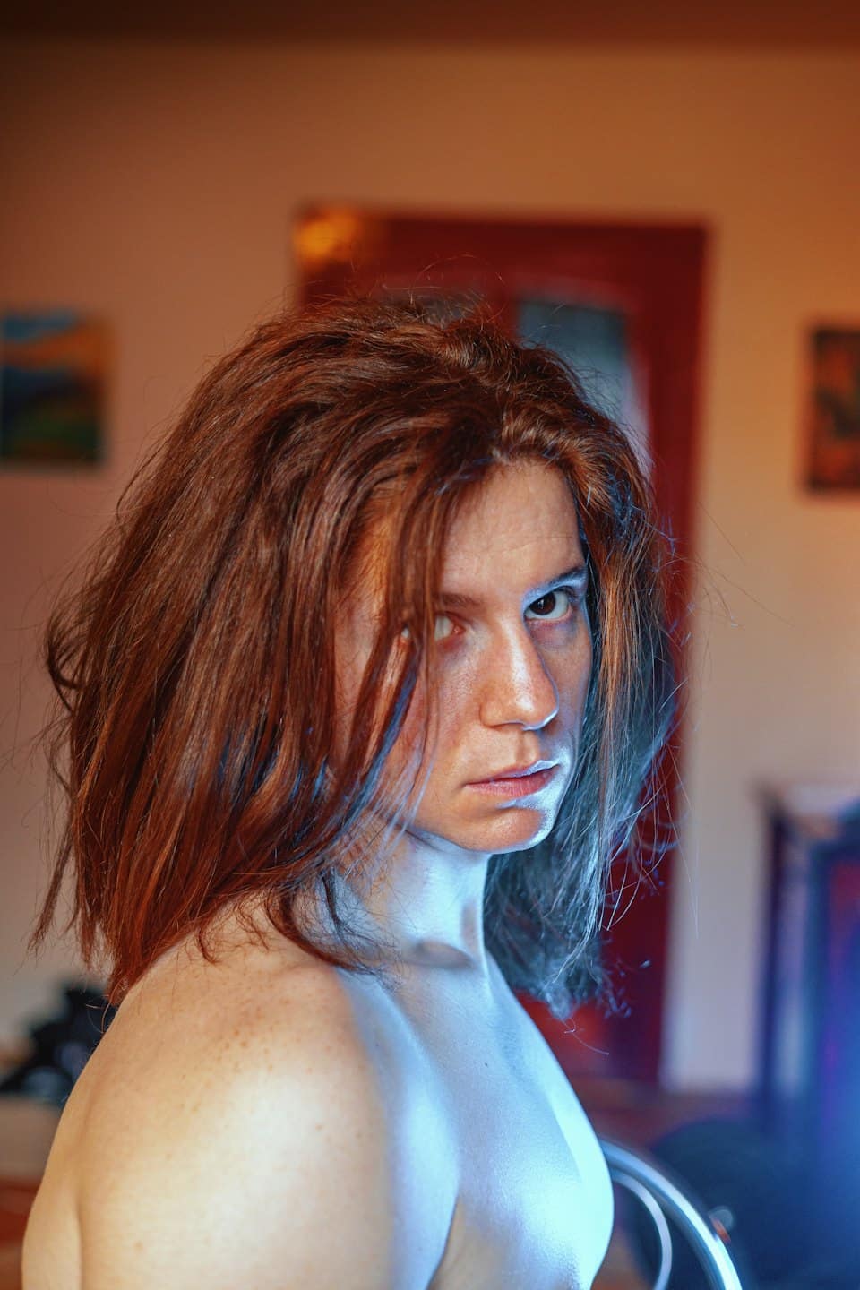 Persona con lunghi capelli castano-rossicci che guarda avanti.